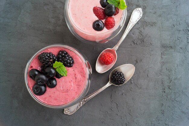 Jagodowy jogurt naturalny w szklanej misce.