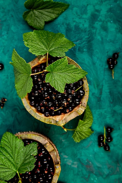 Jagody z czarnej porzeczki z liśćmi, czarna porzeczka