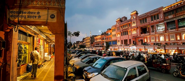 Jaipur, Indie, 5 Stycznia 2020 R.; Widok Na Centralną Ulicę Wieczorem. Liczne Sklepy I Ruch Z Transportu.