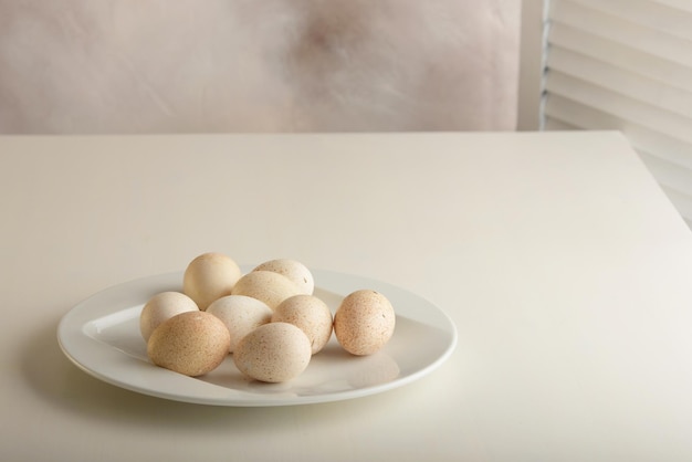 Jaja indycze w białych naczyniach na jasno barwionej drewnianej powierzchni poziomej