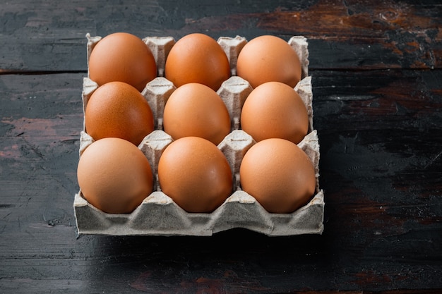 Jaja kurze w tacce pole jajko zestaw na tle stary ciemny drewniany stół