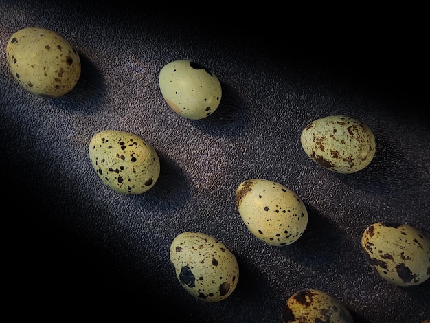 Jaja przepiórcze z przepiórek zbiór jaj przepiórczych na drewnianym talerzu z czarnym tłem piasku