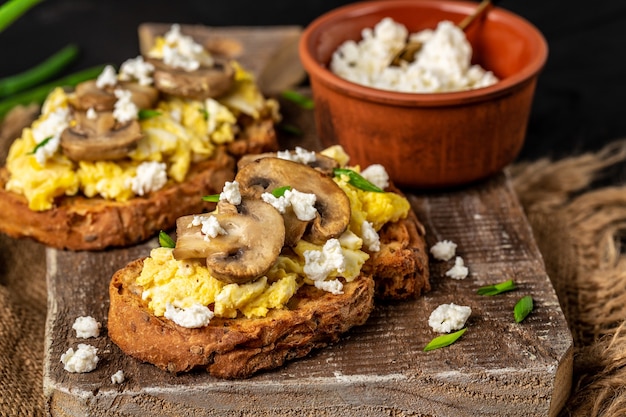 Jajecznica z pieczarkami na chrupiącym pieczywie pszenno-żytnim, zdrowe śniadanie lub brunch.