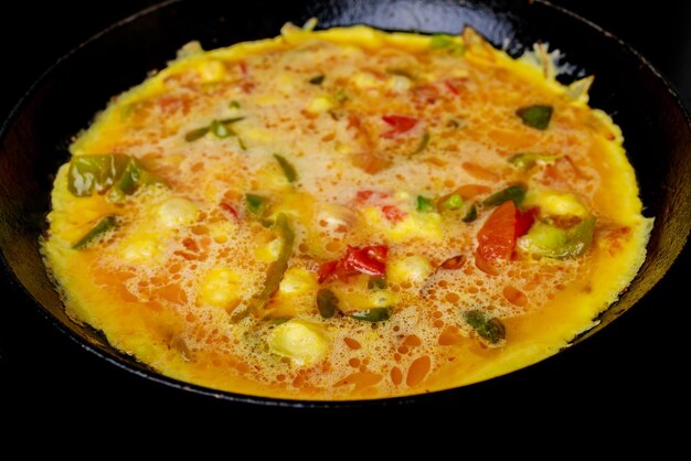 Jajka i warzywa są mieszane razem, aby zrobić wegetariański omlet