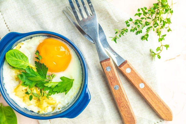 Zdjęcie jajka kokot cocotte śniadanie francuskie jajka pieczone w niebieskich ceramicznych foremkach do pieczenia porcjowana zapiekanka z warzyw i jajek po włosku