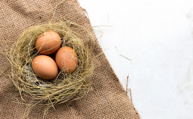 Jajka na burlap z starym drewnem. nad światłem