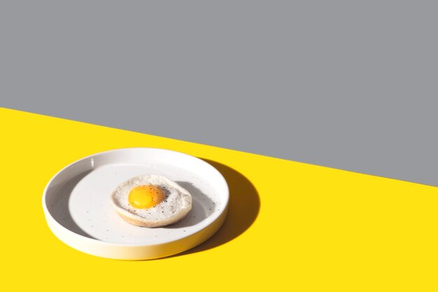 Jajko sadzone na białym talerzu Kolor roku 2021
