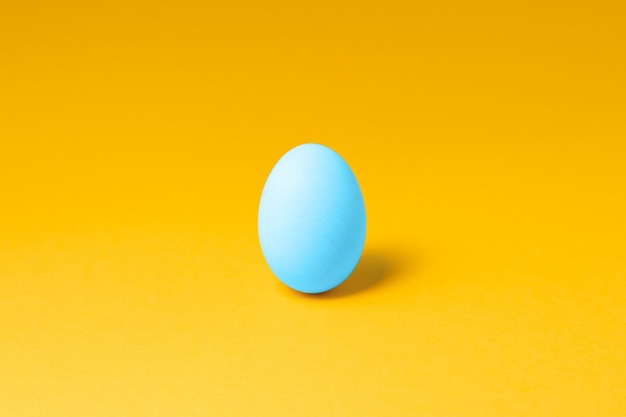 Jajko w pastelowym niebieskim kolorze w środku wielkanocnej dekoracji. projekt koncepcyjny wielkanocy