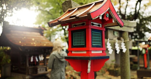 Japonia natura i drewniana latarnia w Kioto z drzewami turysta i kobieta z bramą torii Architektura japońska kultura i świątynia szintoistyczna w lesie ze rzeźbą religia pomnik i pomnik