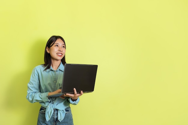 Japonka korzysta z laptopa przeglądającego Internet na żółtym tle