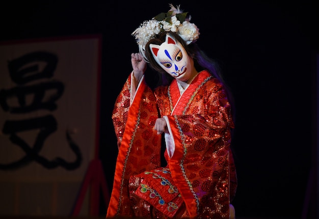 Japońscy aktorzy teatralni wykonują taniec orientalny w maskach.