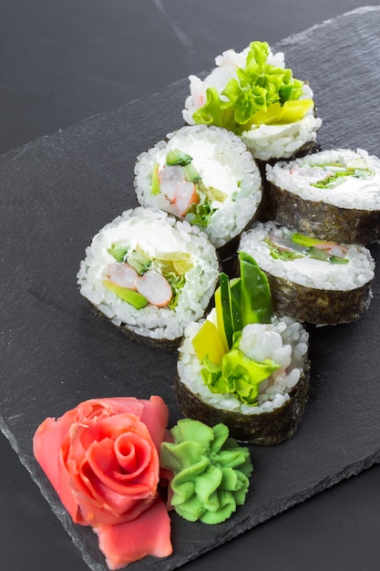 Japońska restauracja, sushi roll na czarnej płycie łupkowej.