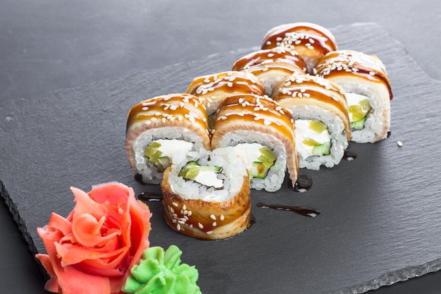 Japońska restauracja, sushi roll na czarnej płycie łupkowej.