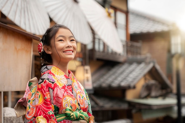 Zdjęcie japońska turystka w tradycyjnej czerwonej sukience kimono spacerująca ulicą w świątyni gion