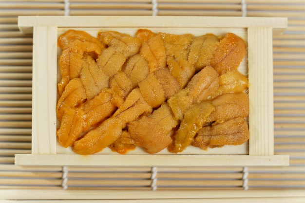 Zdjęcie japoński jeżowca w drewnianej tacy, sushi i składników sashimi