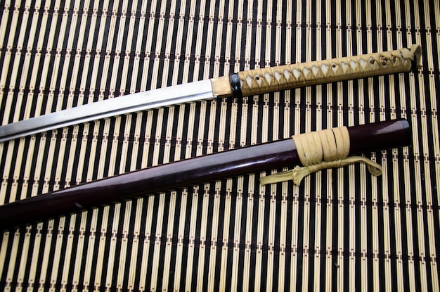 Zdjęcie japoński miecz katana i pochwa na bambusowej macie