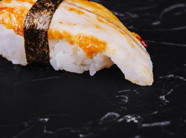 Japoński sushi węgorz nigiri na białym tle na czarnym tle