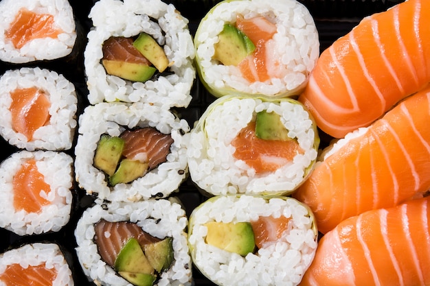 Japońskie jedzenie: maki i nigiri sushi ustawione na czarno. Ścieśniać