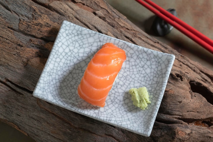 Zdjęcie japońskie jedzenie sushi z łososia na talerzu ma pałeczki na drewnianym tle