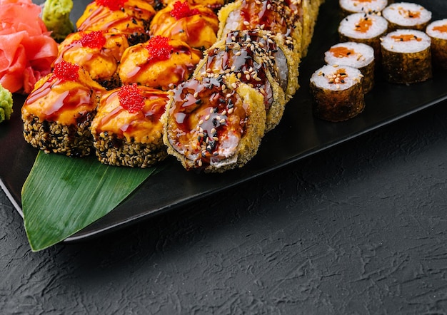 Zdjęcie japońskie sushi na czarnym kamiennym talerzu