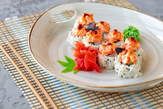 Japońskie sushi z sezamem i polewą kremową na szarym tle