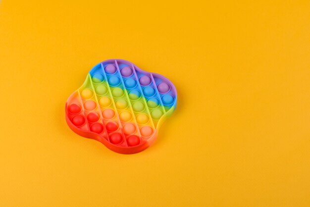 Jasna kolorowa zabawka dla dzieci wykonana z silikonu, zaprojektowana w celu łagodzenia stresu na jednotonowej powierzchni papieru