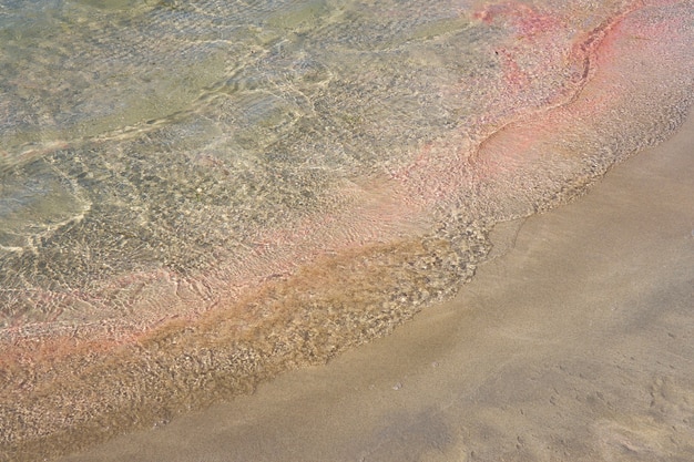 Jasne fale na kolorowej tropikalnej plaży Elafonissi na Krecie w Grecji.