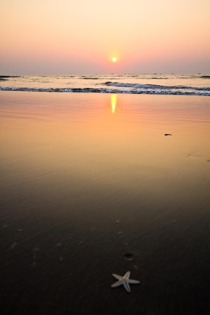 Jasne pomarańczowe niebo o zachodzie słońca na plaży, South Goa, Indie