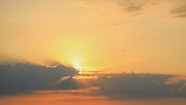 Jasne promienie słoneczne na pomarańczowym niebie słońca z chmurami cumulus