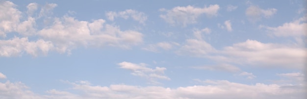 Jasne, spokojne błękitne niebo, nad którym białe chmury unoszą się powoli jak fale Baner tła Wygaszacz ekranu na monitorze