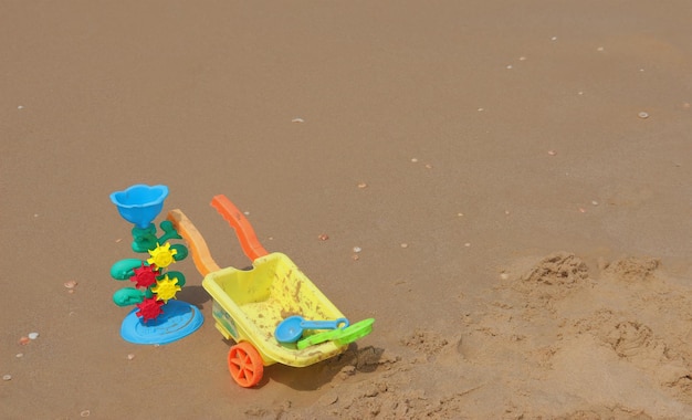 Jasne zabawki dla dzieci na mokrym piasku z muszlami