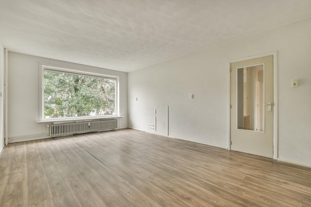 Jasny i pusty salon z dużym oknem