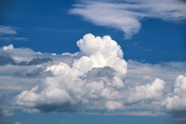 Jasny krajobraz białych podpuchniętych chmur cumulus na błękitne jasne niebo.