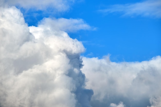 Jasny krajobraz białych podpuchniętych chmur cumulus na błękitne jasne niebo.