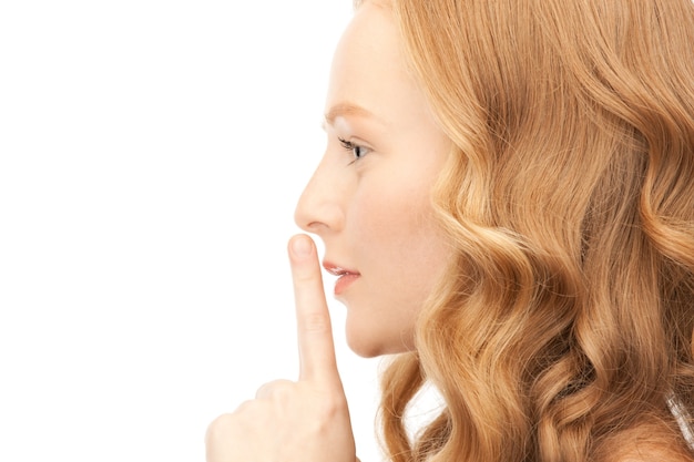 Zdjęcie jasny obraz młodej kobiety z palcem na ustach