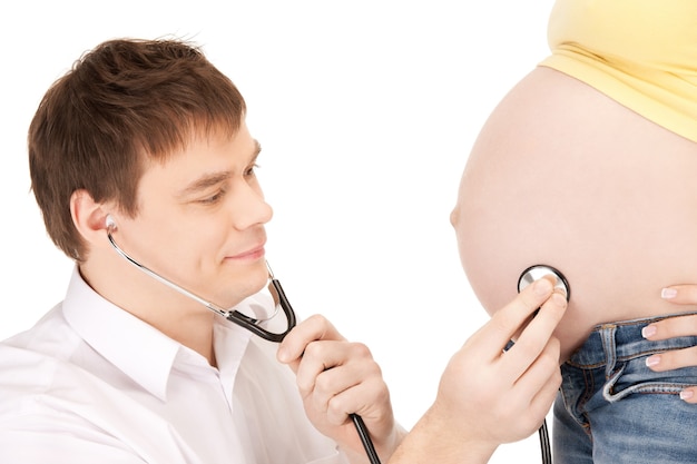 jasny obraz zbliżenia przedstawiający lekarza i brzuch kobiety w ciąży