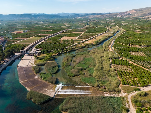 Jaz Antella na rzece Jucar (Azud de Antella) otoczony polami pomarańczowymi w prowincji Walencja w Hiszpanii
