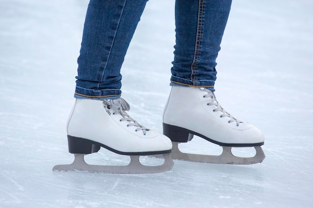 Jazda na łyżwach na lodowisku. nogi z łyżwami. Zimowe aktywne hobby sportowe i rekreacyjne.