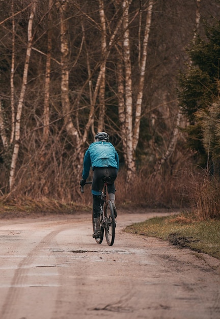 Jazda rowerem Gravel w deszczowej pogodzie Bikerider od tyłu w kasku ochronnym Nowoczesny rower