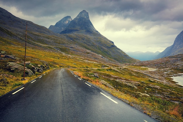 Jazda samochodem po górskiej drodze Droga wśród gór z dramatycznym pochmurnym niebem Krajobraz Piękna przyroda Norwegia