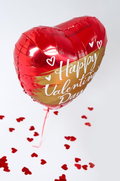 Zdjęcie jeden czerwony żelowy balon na imprezę walentynki z literami i sercami na białym tle.