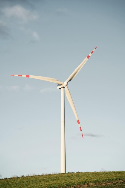 Jeden młyn turbinowy Turbina wiatrowa w zielonym polu przeciw błękitne niebo z puszystymi chmurami Koncepcja zielonej energii i zrównoważonej przyszłości