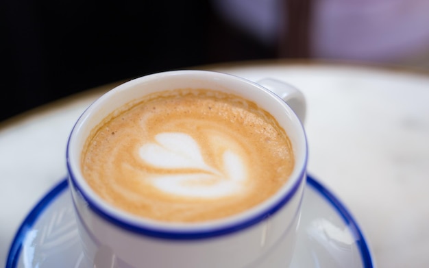 Jedna Filiżanka Cappuccino Z Latte Art Kawa W Niebieskiej Filiżance Na Drewnianym Stole W Kawiarni Koncepcja łatwego śniadania