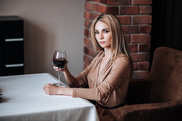 Jedna kobieta pije czerwone wino w restauracji