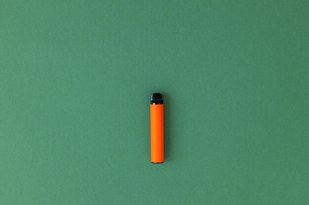 Jednorazowe elektroniczne papierosy z cieniem na zielonym tle z paleniem miejsca na kopię