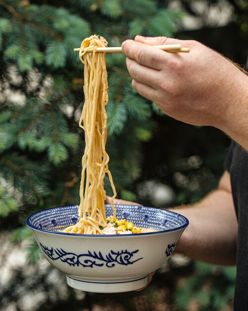 Jedzenie Japońskiej Zupy Z Makaronem Ramen Z Pałeczkami