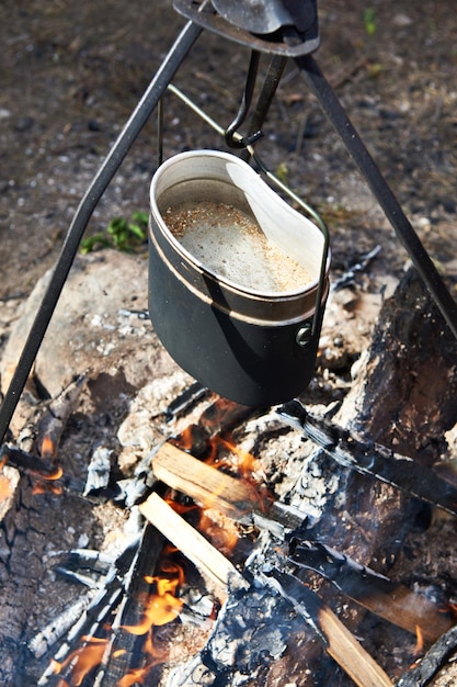 Jedzenie jest przygotowywane w garnku nad ogniskiem podczas wędrówki