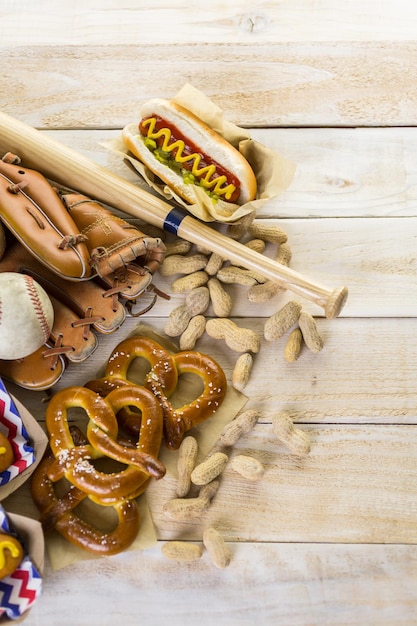 Jedzenie na imprezę baseballową z kulkami i rękawiczkami na drewnianym stole.