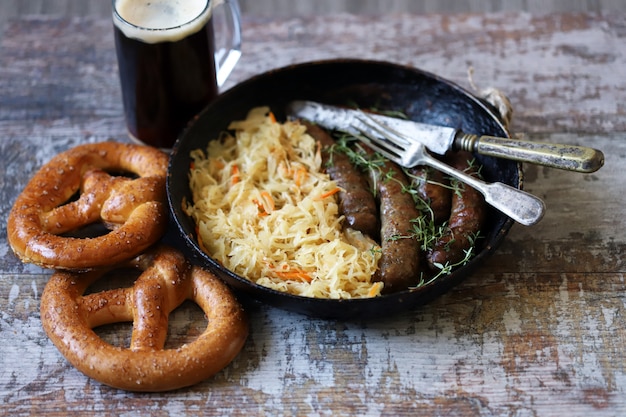 Jedzenie Na Oktoberfest. Gorące Bawarskie Kiełbaski Z Kapustą Na Patelni. Pyszne Piwo Festiwalowe