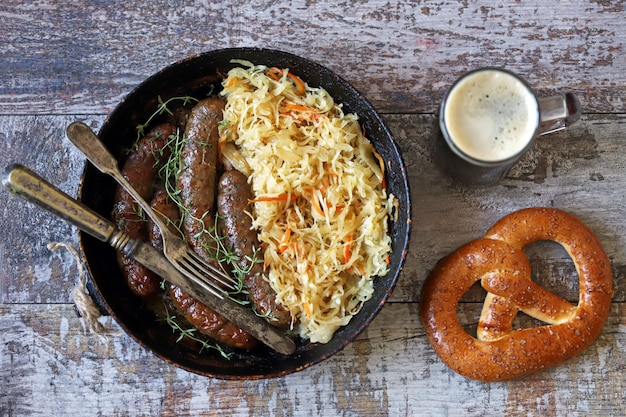 Jedzenie na Oktoberfest. Gorące bawarskie kiełbaski z kapustą na patelni. Pyszne piwo festiwalowe